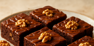 Καρύδινο brownie σοκολάτας σε κομμάτια με γυαλιστερή καραμέλα από πάνω, σε πιάτο σερβιρίσματος
